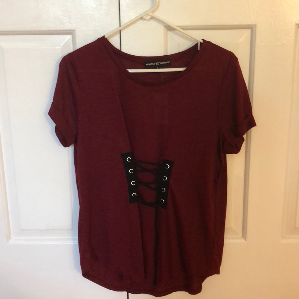 dark red tee shirt from the brand “almost famous”